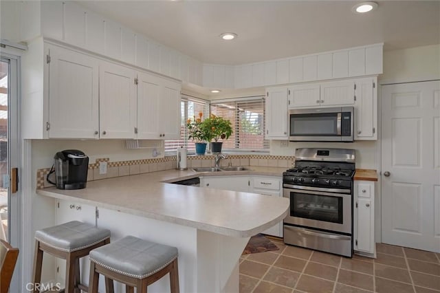6354 Berkshire Ave, Paradise, CA 95969 - kitchen with appliances with stainless steel finishes, a peninsula, light countertops, white cabinetry, and recessed lighting