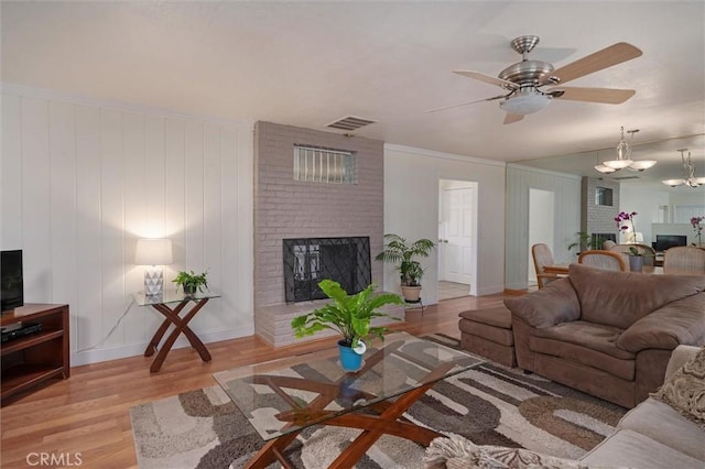 6354 Berkshire Ave, Paradise, CA 95969 - living room featuring light wood finished floors, a ceiling fan, a brick fireplace, and a chandelier