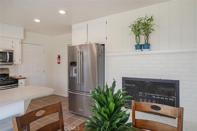 6354 Berkshire Ave, Paradise, CA 95969 - kitchen with appliances with stainless steel finishes, white cabinets, light countertops, tile patterned flooring, and a fireplace