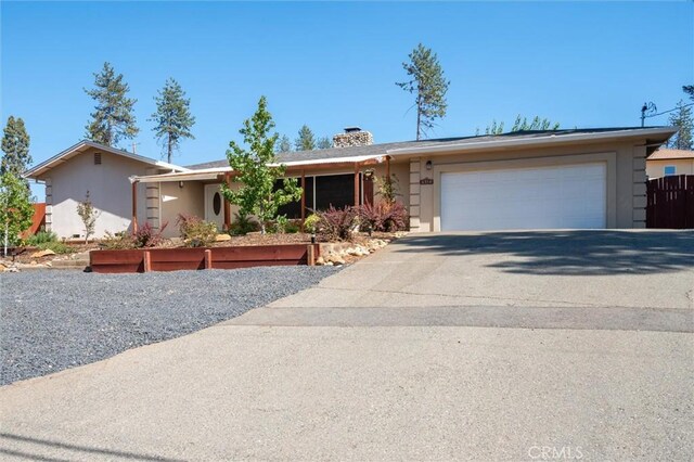 6354 Berkshire Ave, Paradise, CA 95969 - ranch-style home featuring an attached garage, driveway, stucco siding, and a chimney