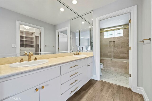 390 S Sepulveda Blvd Unit 105, Los Angeles, CA 90049 - full bathroom with double vanity, recessed lighting, tiled shower / bath combo, and wood finished floors