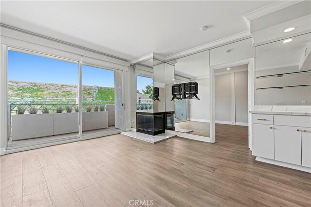 390 S Sepulveda Blvd Unit 105, Los Angeles, CA 90049 - unfurnished living room featuring crown molding, light wood-style flooring, and recessed lighting