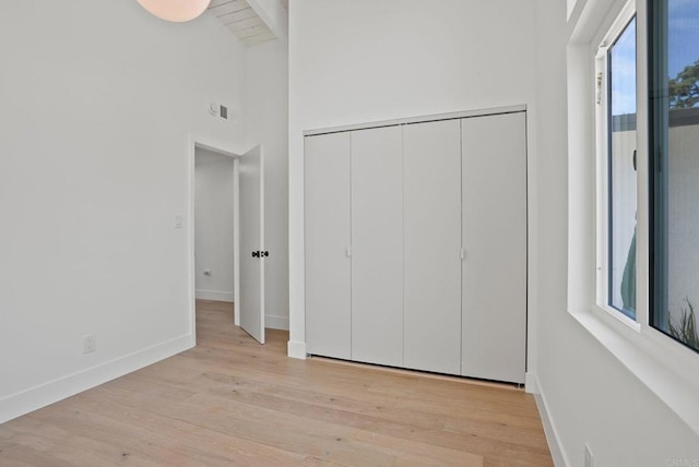 8602 Kilbourn Dr, La Jolla, CA 92037 - unfurnished bedroom featuring light wood-style flooring, high vaulted ceiling, a closet, and beamed ceiling