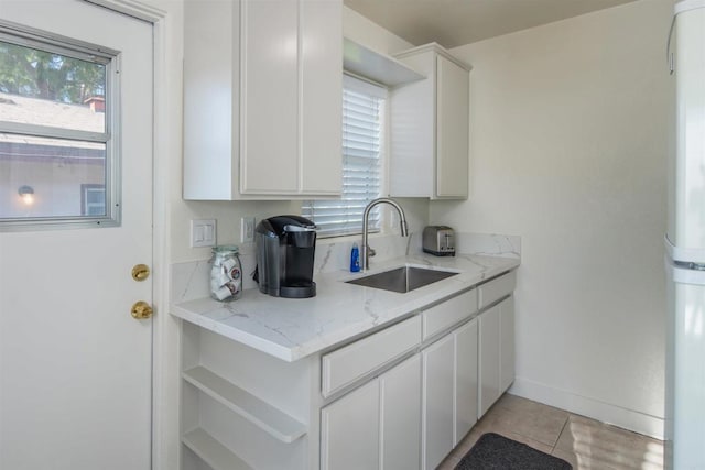 260406 Juan St, San Diego, CA 92110 - kitchen featuring light tile patterned flooring, light stone counters, freestanding refrigerator, and white cabinetry