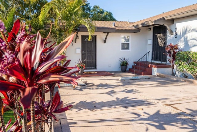 260406 Juan St, San Diego, CA 92110 - view of front of property featuring stucco siding, a patio area, and roof with shingles