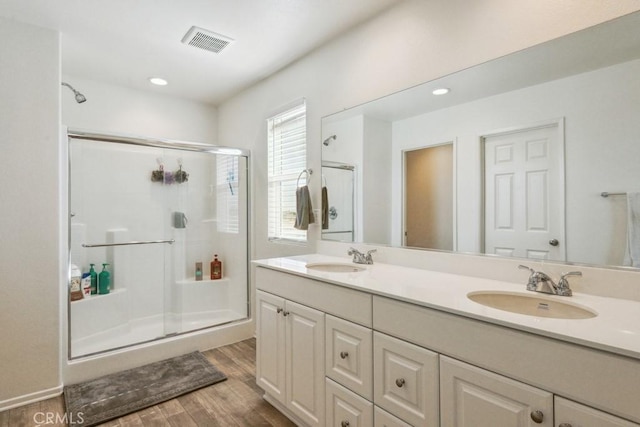 13343 Macaw Pl, Victorville, CA 92395 - bathroom with a stall shower, double vanity, wood finished floors, and recessed lighting