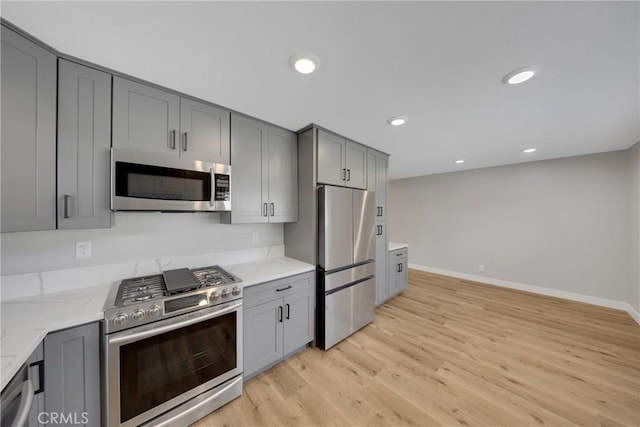1106 W Bellbrook St, Covina, CA 91722 - kitchen with stainless steel appliances, gray cabinets, light wood-style floors, light stone countertops, and recessed lighting