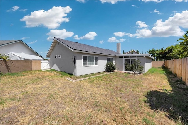 1106 W Bellbrook St, Covina, CA 91722 - rear view of property featuring a fenced backyard, a sunroom, a chimney, and stucco siding