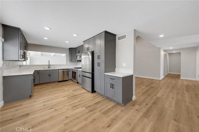 1106 W Bellbrook St, Covina, CA 91722 - kitchen with appliances with stainless steel finishes, gray cabinets, light wood finished floors, light countertops, and recessed lighting