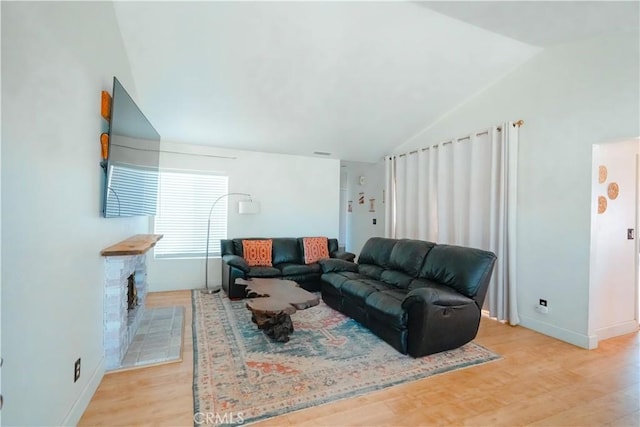 3473 Yankee Cir, Riverside, CA 92503 - living room featuring lofted ceiling, light wood finished floors, and a stone fireplace