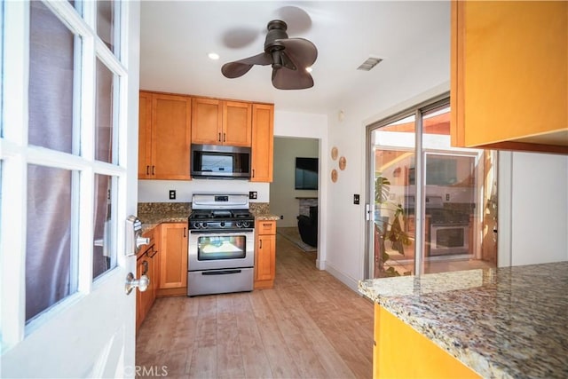 3473 Yankee Cir, Riverside, CA 92503 - kitchen featuring stainless steel appliances, light wood-style flooring, a ceiling fan, and stone counters