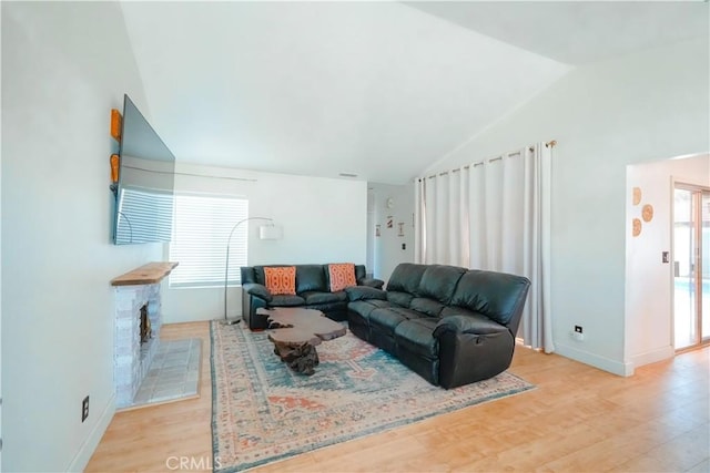 3473 Yankee Cir, Riverside, CA 92503 - living area featuring vaulted ceiling, light wood-type flooring, and a stone fireplace