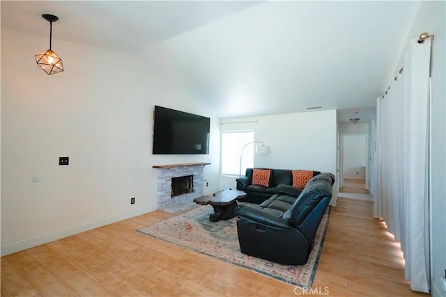 3473 Yankee Cir, Riverside, CA 92503 - living area featuring light wood-type flooring, vaulted ceiling, and a fireplace with flush hearth
