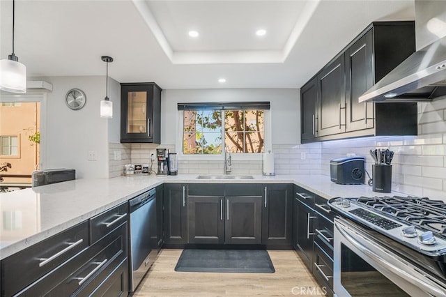 4347 Freedom Dr Unit C, Calabasas, CA 91302 - kitchen featuring wall chimney exhaust hood, stainless steel appliances, light stone countertops, dark cabinets, and recessed lighting