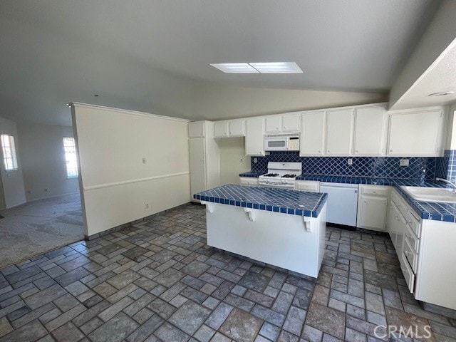 27896 Beacon St, Castaic, CA 91384 - kitchen featuring white appliances, vaulted ceiling, tile counters, a kitchen island, and backsplash