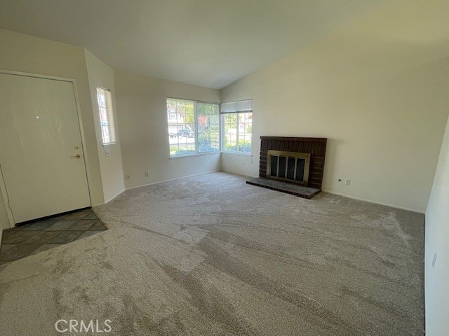 27896 Beacon St, Castaic, CA 91384 - unfurnished living room with carpet floors, vaulted ceiling, and a brick fireplace