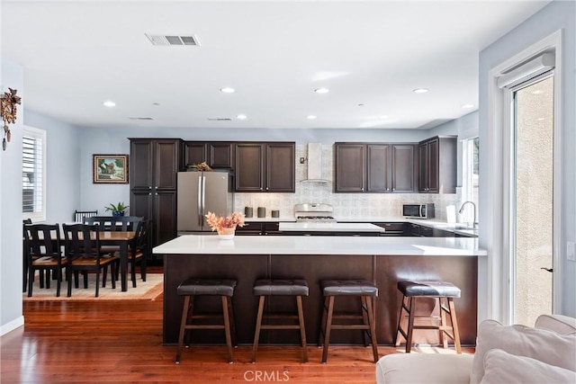 35694 Cherry Bark Way, Murrieta, CA 92562 - kitchen with freestanding refrigerator, wall chimney exhaust hood, dark brown cabinetry, light countertops, and recessed lighting