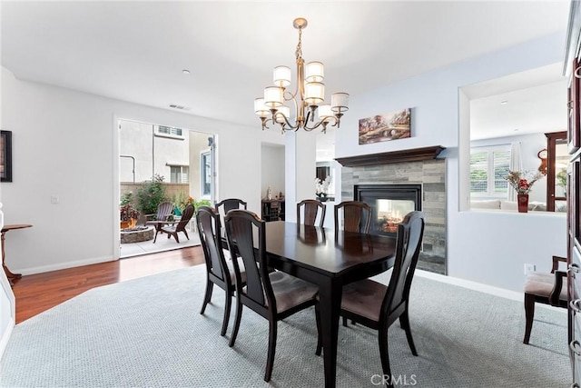 35694 Cherry Bark Way, Murrieta, CA 92562 - dining room featuring a chandelier, a tile fireplace, and wood finished floors