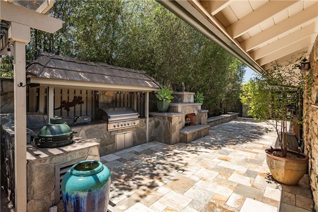 1251 Bryant Rd, Long Beach, CA 90815 - view of patio with an outdoor kitchen and an outdoor stone fireplace