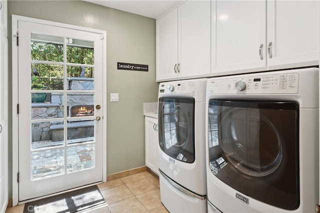 1251 Bryant Rd, Long Beach, CA 90815 - laundry area featuring cabinet space, washer and clothes dryer, and light tile patterned floors