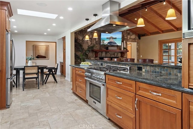 1251 Bryant Rd, Long Beach, CA 90815 - kitchen featuring appliances with stainless steel finishes, island range hood, brown cabinetry, dark stone countertops, and decorative light fixtures