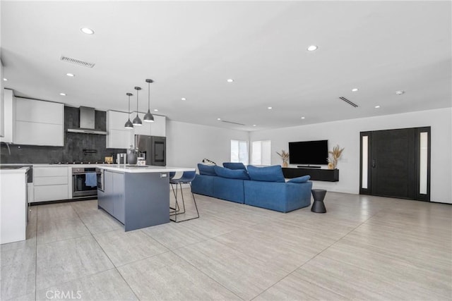 8140 Quartz Ave, Winnetka, CA 91306 - kitchen featuring wall chimney range hood, fridge with ice dispenser, stainless steel oven, a kitchen bar, and white cabinetry
