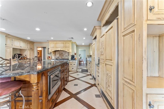 34037 Agua Dulce Canyon Rd, Agua Dulce, CA 91390 - kitchen featuring stainless steel microwave, cream cabinets, a kitchen bar, recessed lighting, and tasteful backsplash