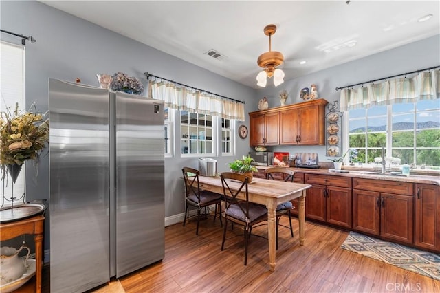 34037 Agua Dulce Canyon Rd, Agua Dulce, CA 91390 - kitchen featuring stainless steel appliances, light wood finished floors, ceiling fan, brown cabinetry, and light countertops