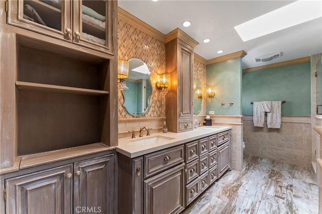 34037 Agua Dulce Canyon Rd, Agua Dulce, CA 91390 - full bath with ornamental molding, double vanity, tile walls, a skylight, and a wainscoted wall