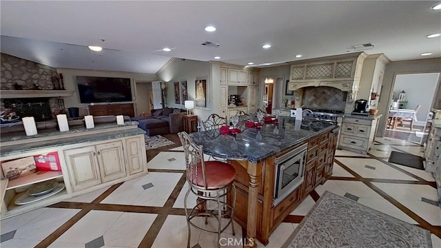 34037 Agua Dulce Canyon Rd, Agua Dulce, CA 91390 - kitchen featuring stainless steel microwave, cream cabinetry, inlaid floor details, recessed lighting, and a breakfast bar area