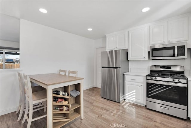 12684 Snapping Turtle Rd, Apple Valley, CA 92308 - kitchen featuring stainless steel appliances, white cabinets, light wood finished floors, light countertops, and recessed lighting