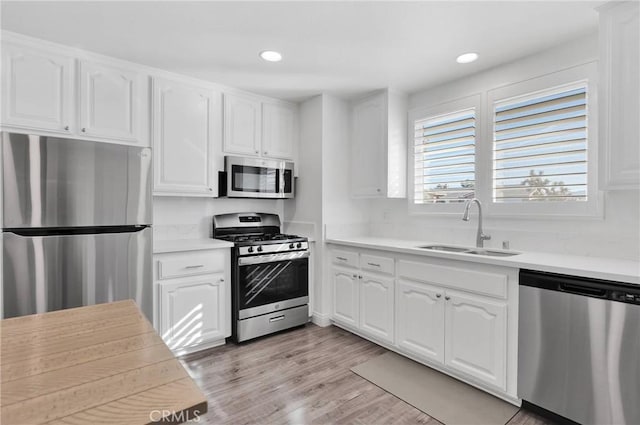 12684 Snapping Turtle Rd, Apple Valley, CA 92308 - kitchen featuring appliances with stainless steel finishes, white cabinetry, light countertops, light wood-style floors, and recessed lighting
