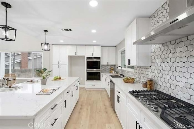 6212 Sacramento Ave, Rancho Cucamonga, CA 91701 - kitchen featuring wall chimney exhaust hood, appliances with stainless steel finishes, white cabinets, light wood-style floors, and recessed lighting