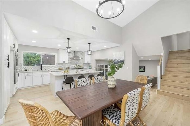 6212 Sacramento Ave, Rancho Cucamonga, CA 91701 - dining space featuring stairs, light wood-type flooring, high vaulted ceiling, a chandelier, and recessed lighting