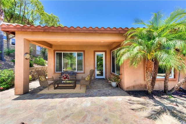 24038 Watercress Dr, Corona, CA 92883 - view of exterior entry featuring a patio area, stucco siding, and an outdoor living space