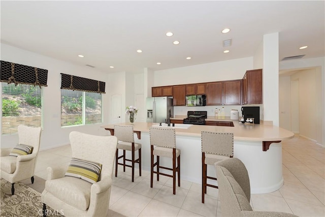 24038 Watercress Dr, Corona, CA 92883 - kitchen with black range, refrigerator with ice dispenser, light countertops, light tile patterned flooring, and a peninsula