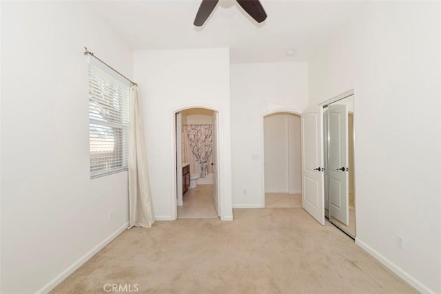 24038 Watercress Dr, Corona, CA 92883 - unfurnished bedroom featuring light colored carpet, arched walkways, connected bathroom, and a ceiling fan