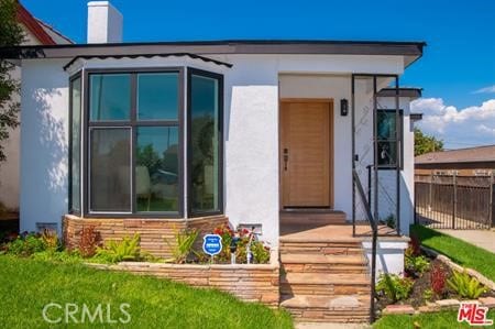 4263 W 59th St, Los Angeles, CA 90043 - view of exterior entry featuring stucco siding and a chimney