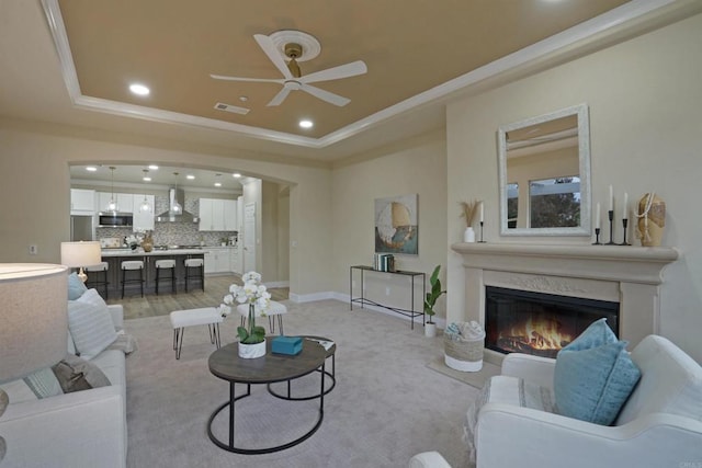 3017 Rue Montreux, Escondido, CA 92026 - living room featuring crown molding, a ceiling fan, a raised ceiling, recessed lighting, and a glass covered fireplace