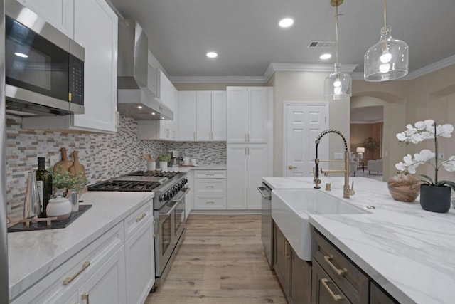3017 Rue Montreux, Escondido, CA 92026 - kitchen with stainless steel appliances, wall chimney range hood, crown molding, white cabinets, and tasteful backsplash