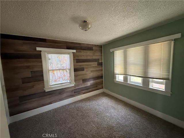 615 E 12th St, Pomona, CA 91766 - carpeted spare room featuring wooden walls, plenty of natural light, and a textured ceiling
