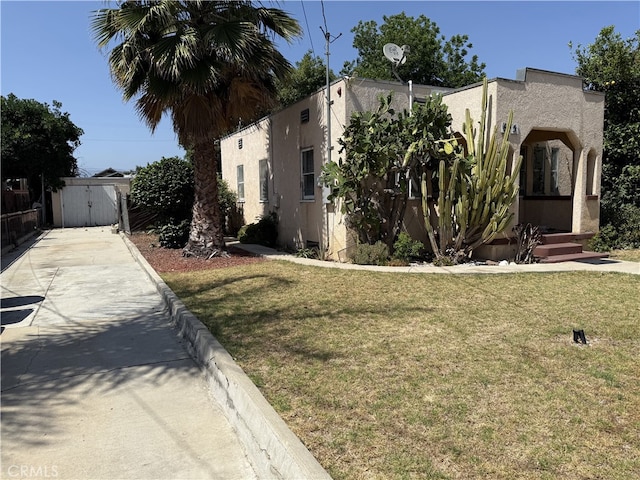 615 E 12th St, Pomona, CA 91766 - view of front facade featuring concrete driveway, stucco siding, a front yard, and a gate