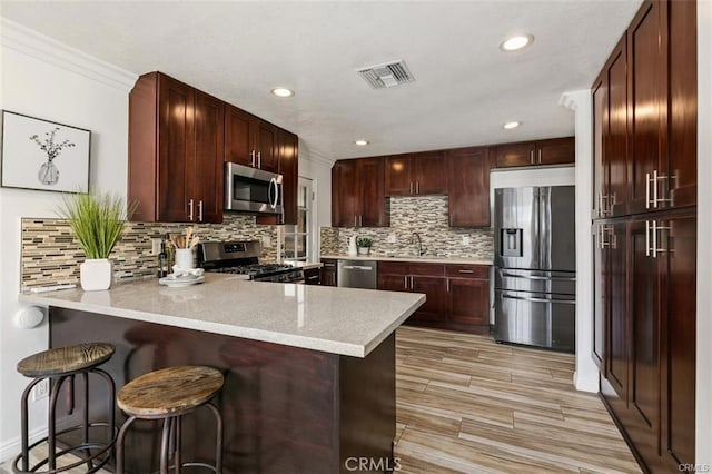 24252 Palmek Cir, Lake Forest, CA 92630 - kitchen featuring stainless steel appliances, a peninsula, light countertops, backsplash, and recessed lighting