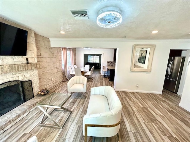 24252 Palmek Cir, Lake Forest, CA 92630 - living room featuring a fireplace with raised hearth, crown molding, wood finished floors, and recessed lighting