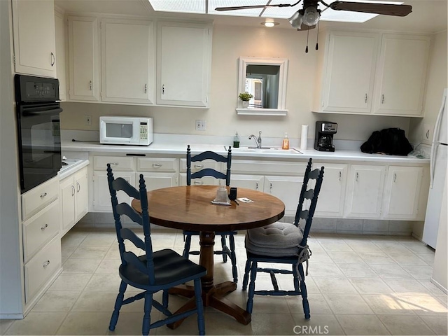13361 N Fairfield Unit 180J, Seal Beach, CA 90740 - kitchen featuring white appliances, ceiling fan, light countertops, and white cabinetry
