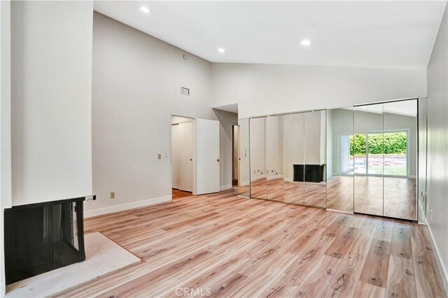 23415 Park Hacienda, Calabasas, CA 91302 - unfurnished living room with a multi sided fireplace, light wood-style flooring, high vaulted ceiling, and recessed lighting