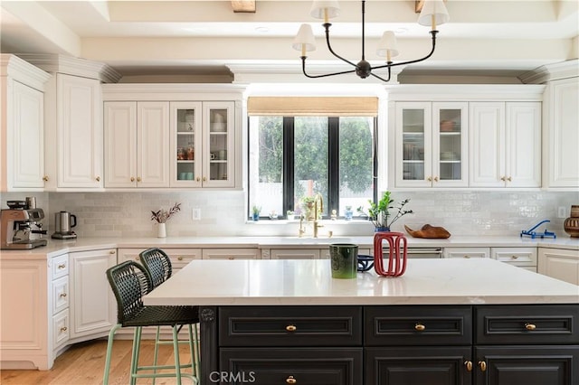 4620 Morse Ave, Sherman Oaks, CA 91423 - kitchen featuring dark cabinetry, white cabinets, a chandelier, light countertops, and decorative backsplash