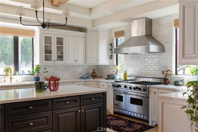4620 Morse Ave, Sherman Oaks, CA 91423 - kitchen featuring wall chimney exhaust hood, range with two ovens, white cabinetry, light countertops, and healthy amount of natural light