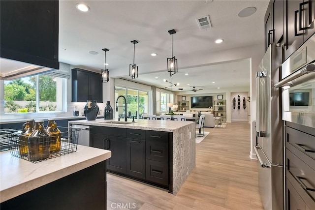 3042 Mesa Gln, Escondido, CA 92026 - kitchen featuring a kitchen island with sink, recessed lighting, appliances with stainless steel finishes, decorative backsplash, and open floor plan