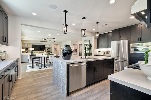 3042 Mesa Gln, Escondido, CA 92026 - kitchen featuring appliances with stainless steel finishes, extractor fan, recessed lighting, hanging light fixtures, and a center island with sink